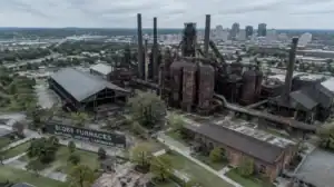 Old Birmingham steel factory with smokestacks and industrial structures.
